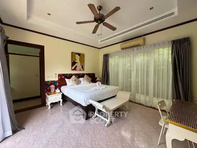 Spacious bedroom with elegant decor and large windows offering natural light.