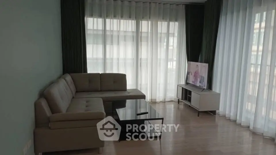 Spacious living room with modern sofa and large windows for natural light.