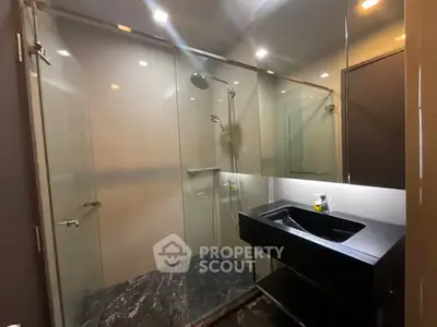 Modern bathroom with glass shower and sleek black sink