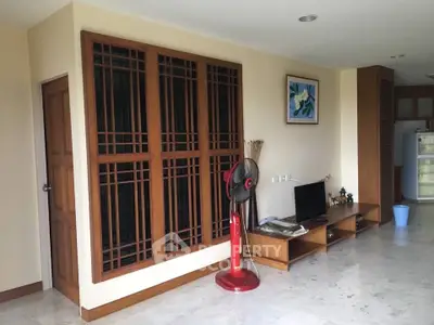 Spacious living room with modern wooden decor and marble flooring