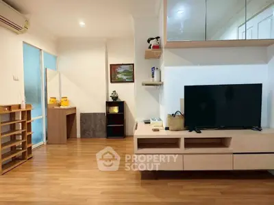 Modern living room with wooden flooring and sleek TV unit