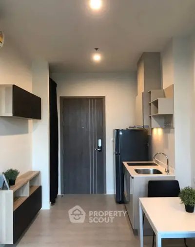 Modern compact kitchen with sleek design and integrated appliances in a stylish apartment.