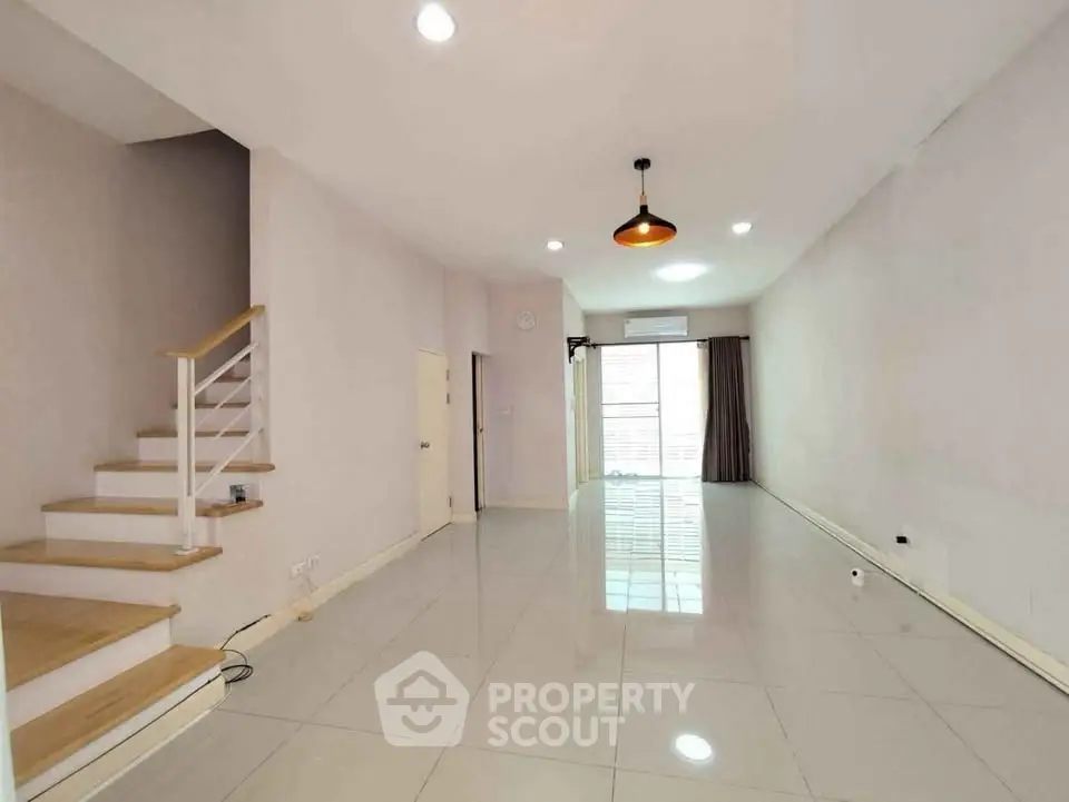 Spacious modern living room with staircase and large windows