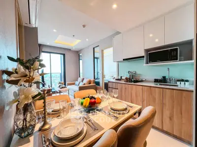Modern open-plan kitchen and living room with elegant dining setup and city view.