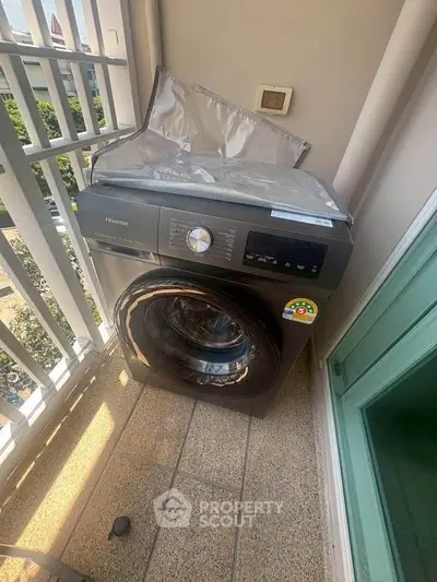 Modern washing machine on a balcony with a view, perfect for urban living convenience.