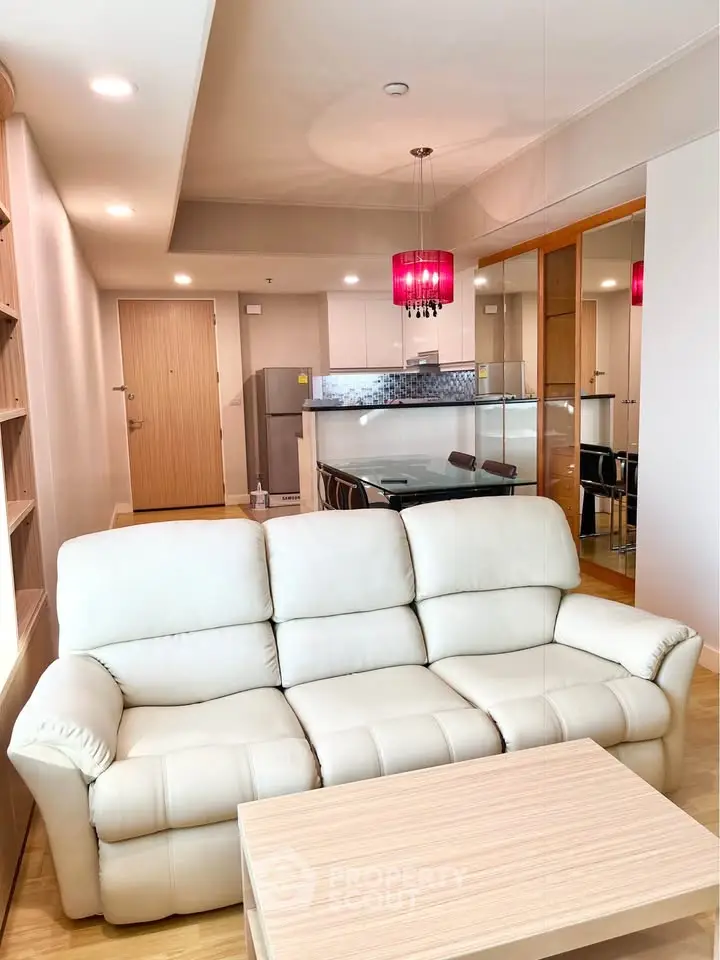 Spacious living room with modern furniture and open kitchen layout in a stylish apartment.