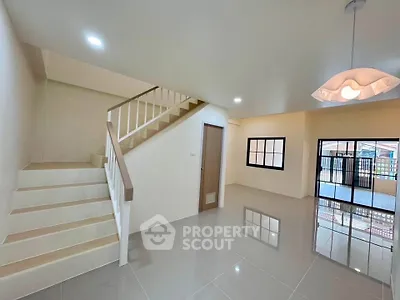 Spacious modern living room with staircase and large windows, perfect for family gatherings.