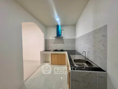 Modern kitchen with sleek black countertops and gas stove in minimalist design.