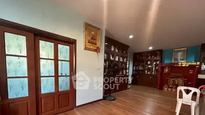 Spacious living room with wooden floors and elegant glass cabinets