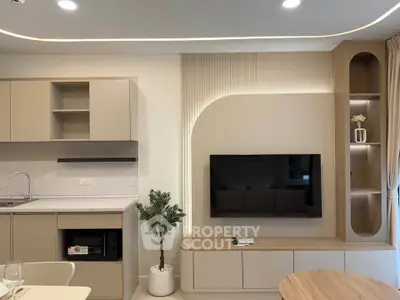 Modern living room with sleek built-in TV unit and stylish kitchen area