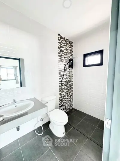 Modern bathroom with sleek design, featuring a walk-in shower and contemporary fixtures.