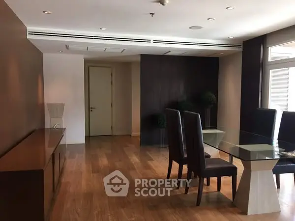 Elegant dining area with modern glass table and wooden flooring
