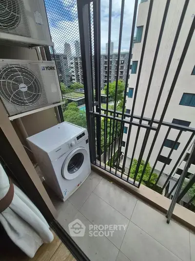 Modern apartment balcony with washing machine and city view