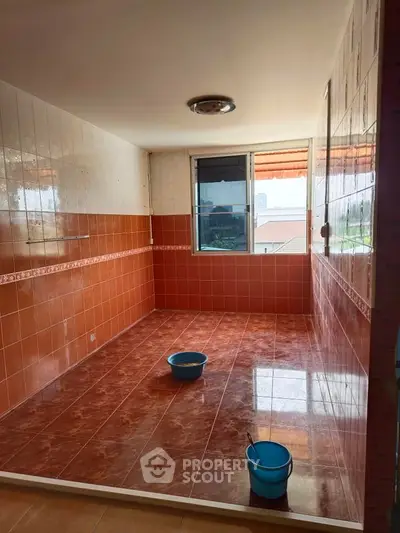 Spacious tiled room with large window and bright natural light