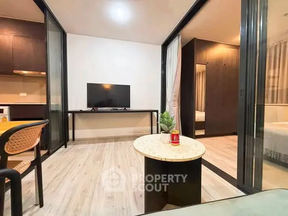Modern living room with sleek design and open layout, featuring a TV and stylish furniture.