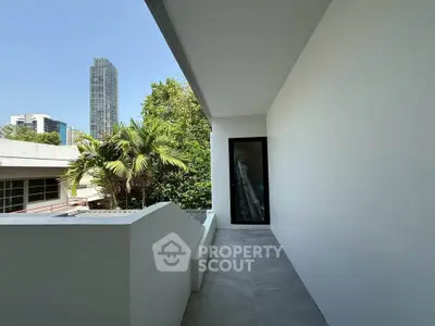 Spacious modern balcony with city view and lush greenery, perfect for relaxation and outdoor enjoyment.
