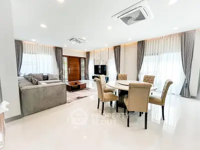 Spacious modern living room with elegant dining area and plush seating.
