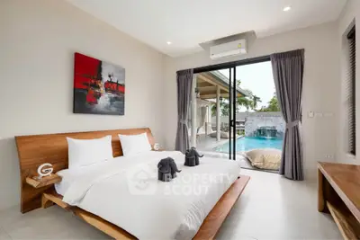 Luxurious bedroom with pool view and modern decor in a serene setting.