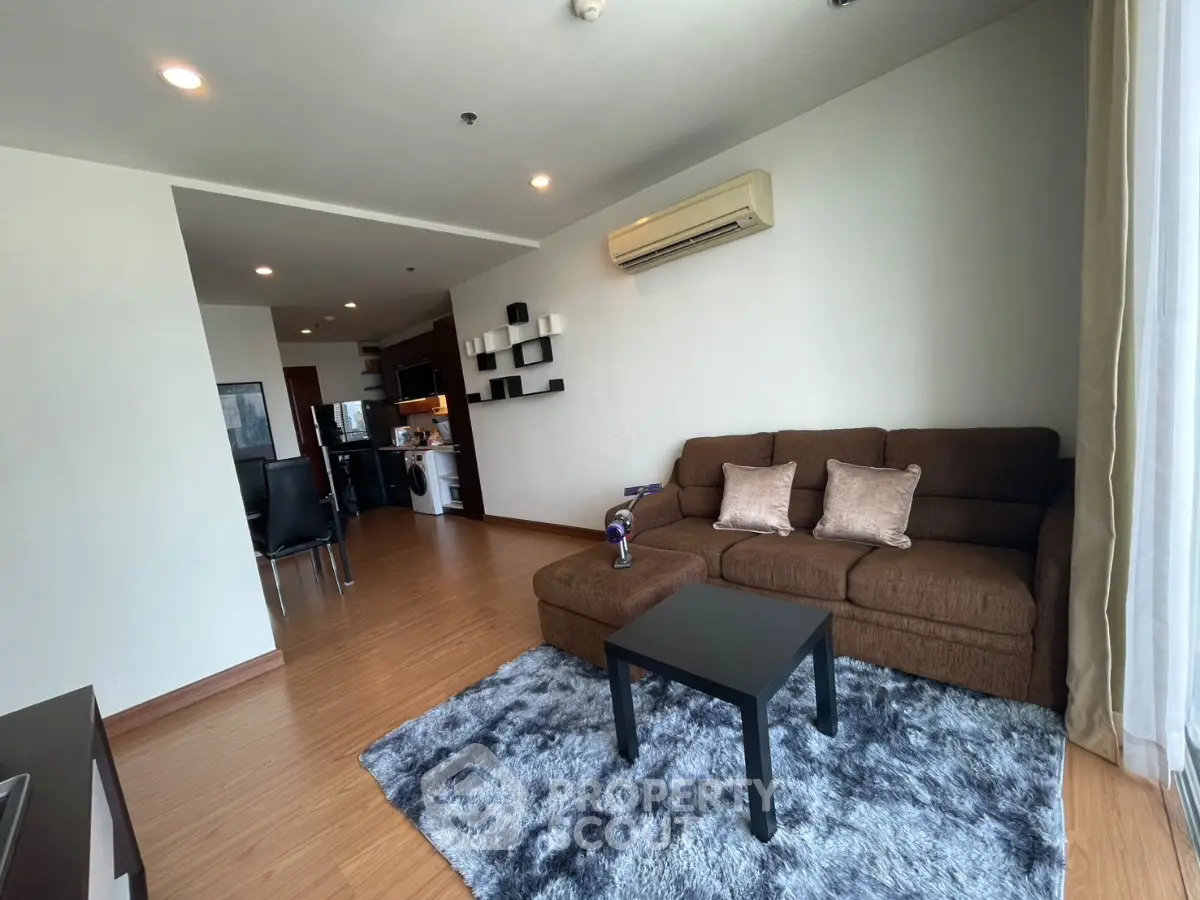 Spacious living room with modern furniture and open kitchen layout in a stylish apartment.