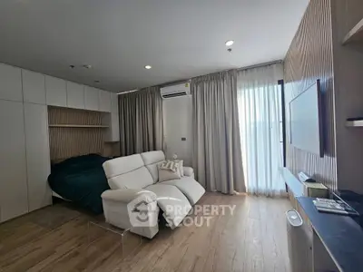 Modern living room with cozy seating and natural light, featuring sleek design and stylish decor.