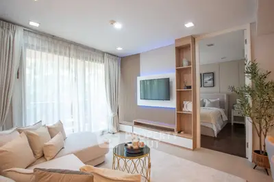 Modern living room with cozy sofa and stylish decor leading to a bedroom