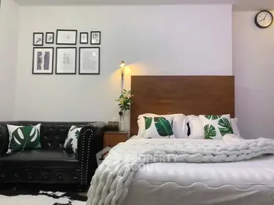 Stylish bedroom with modern decor and cozy ambiance, featuring a plush bed and elegant sofa.
