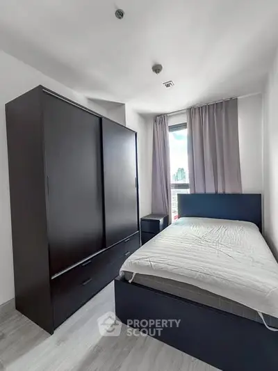 Modern bedroom with sleek furniture and city view, perfect for urban living.