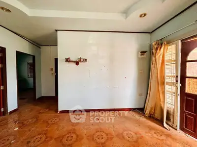 Spacious interior with potential for renovation, featuring tiled floors and natural light.