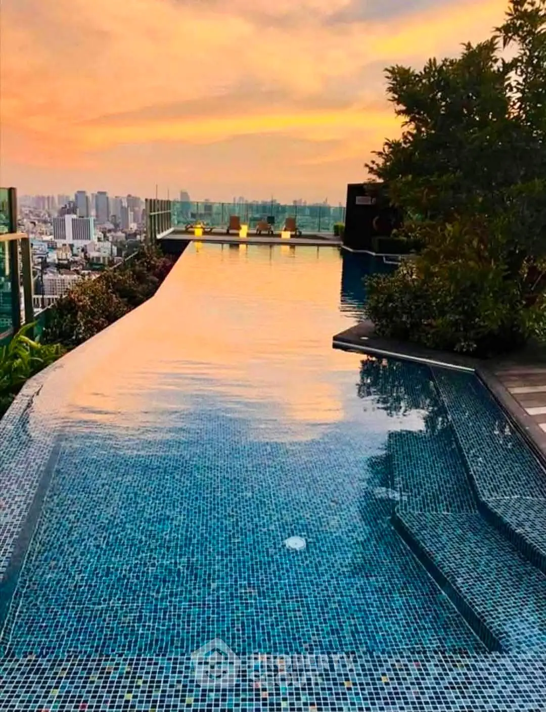 Stunning rooftop infinity pool with breathtaking city skyline views at sunset.