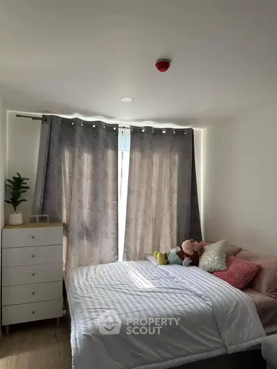 Cozy bedroom with natural light filtering through elegant curtains, featuring a comfortable bed with plush pillows and a stylish dresser.