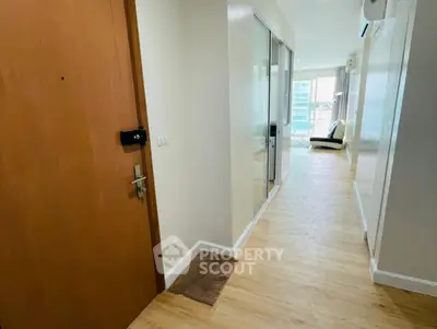 Spacious apartment hallway leading to a bright living area with modern decor.