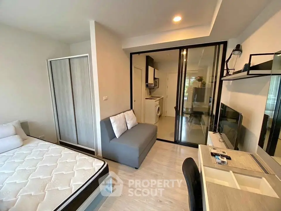 Modern studio apartment with open layout, featuring a cozy living area, compact kitchen, and stylish furnishings.