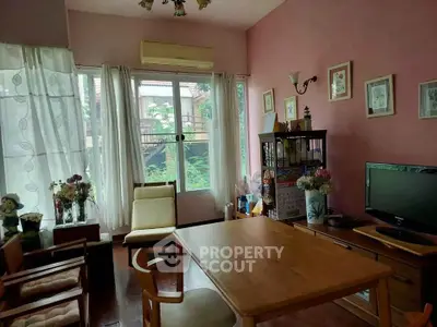 Charming living room with wooden furniture and garden view, perfect for cozy gatherings.