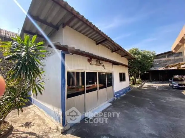Charming single-story house with spacious driveway and lush greenery, perfect for serene living.