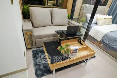 Modern living room with cozy sofa, stylish coffee table, and elegant decor in a compact apartment setting.