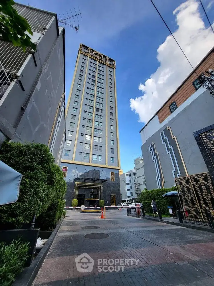 Stunning high-rise building with modern architecture and lush greenery entrance.