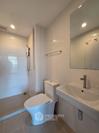 Modern bathroom with sleek fixtures and spacious shower area in a contemporary home.