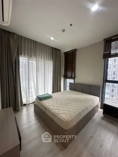 Modern bedroom with large windows and natural light in urban apartment