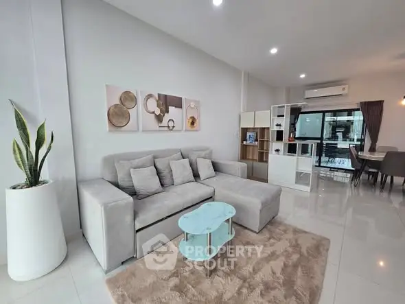 Modern living room with stylish decor and open layout, featuring a cozy sectional sofa and elegant coffee table.