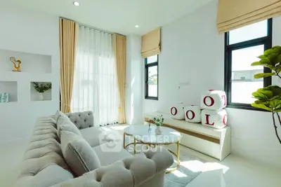 Elegant living room with plush sofa and modern decor, featuring large windows and abundant natural light.