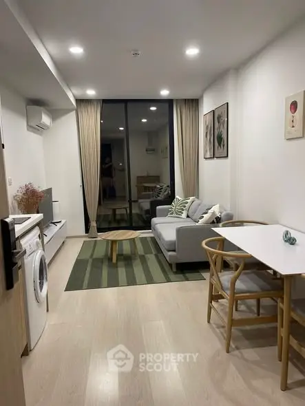 Modern living room with stylish decor and balcony view in a cozy apartment.