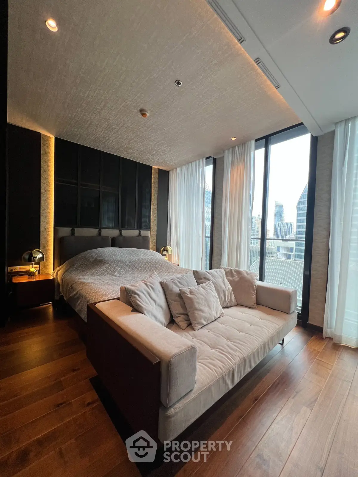 Luxurious bedroom with modern decor and city view, featuring a cozy bed and elegant lighting.