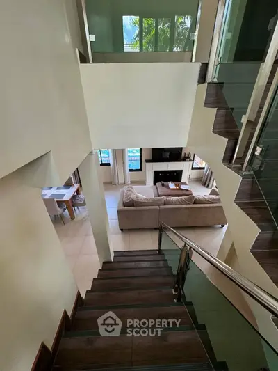 Elegant multi-level home with modern staircase and spacious living area, perfect for family gatherings.