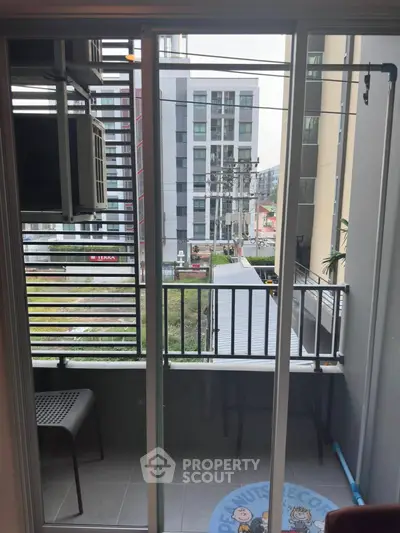 Modern apartment balcony with city view and outdoor seating