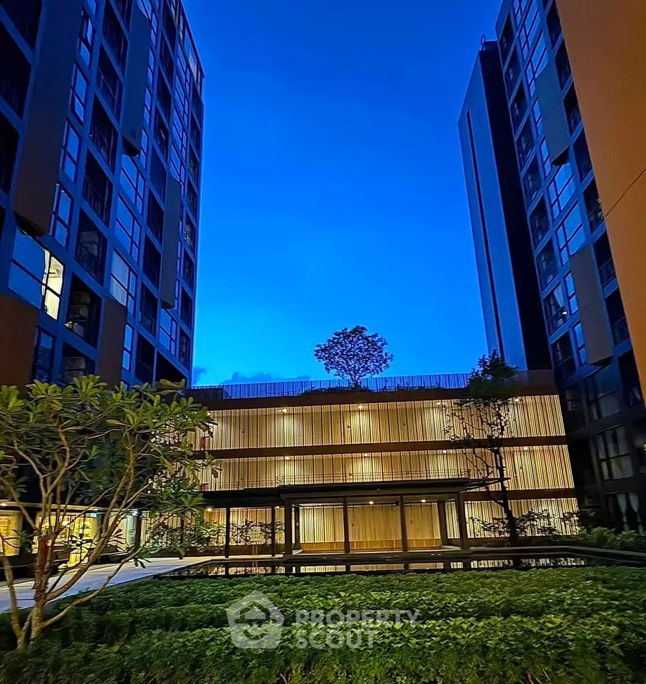 Stunning evening view of modern apartment complex with lush greenery and elegant architecture.