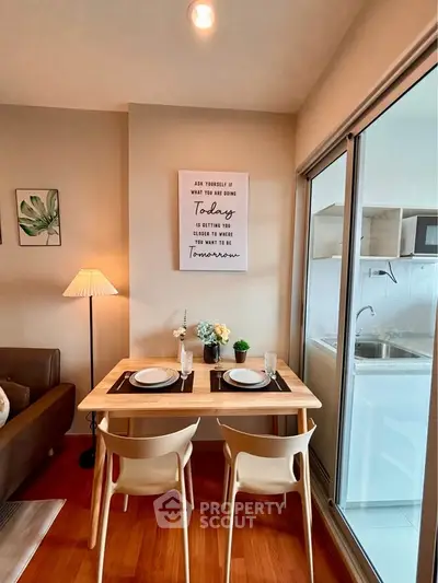Cozy dining area with modern decor and adjacent kitchen in stylish apartment.