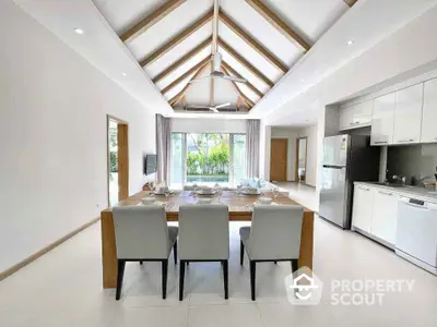 Spacious modern dining area with vaulted ceiling and garden view