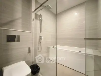 Modern bathroom with sleek design, featuring a glass shower and bathtub.