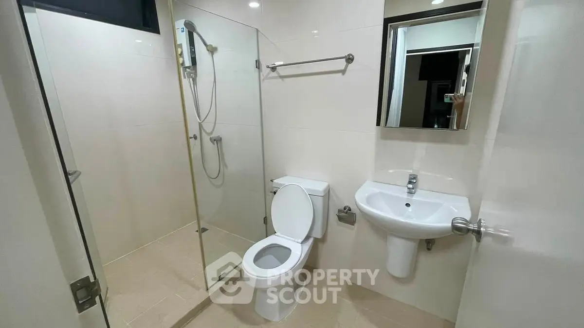 Modern bathroom with glass shower and sleek fixtures in a contemporary home.