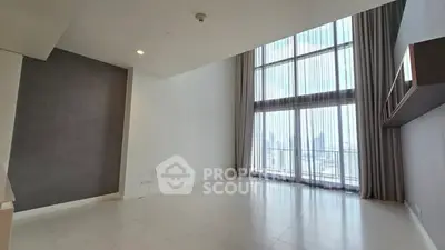 Spacious modern living room with floor-to-ceiling windows and city view